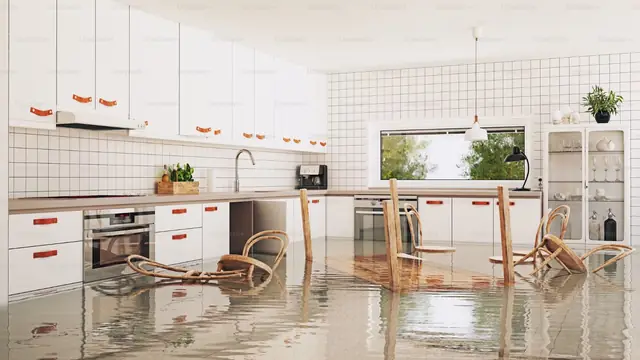 Condo kitchen with standing water across the floor and chairs sitting in it